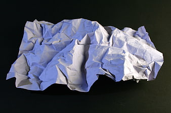Crumpled white paper texture on black background