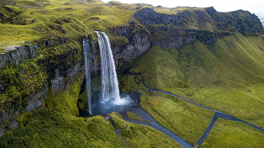 Aerial View of Majestic Waterfall in Lush Green Icelandic Landscape