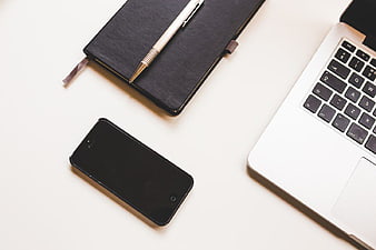 Minimalist workspace with laptop, smartphone, and notebook