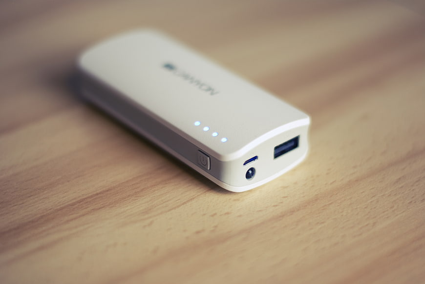 White portable power bank on wooden table