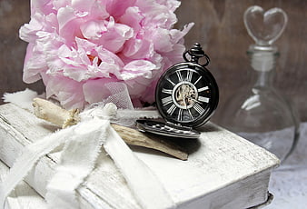 Vintage pocket watch and pink peony on old white book