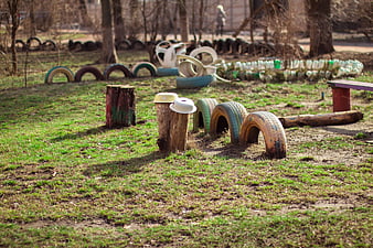 Outdoor playground with painted tires and wooden stumps