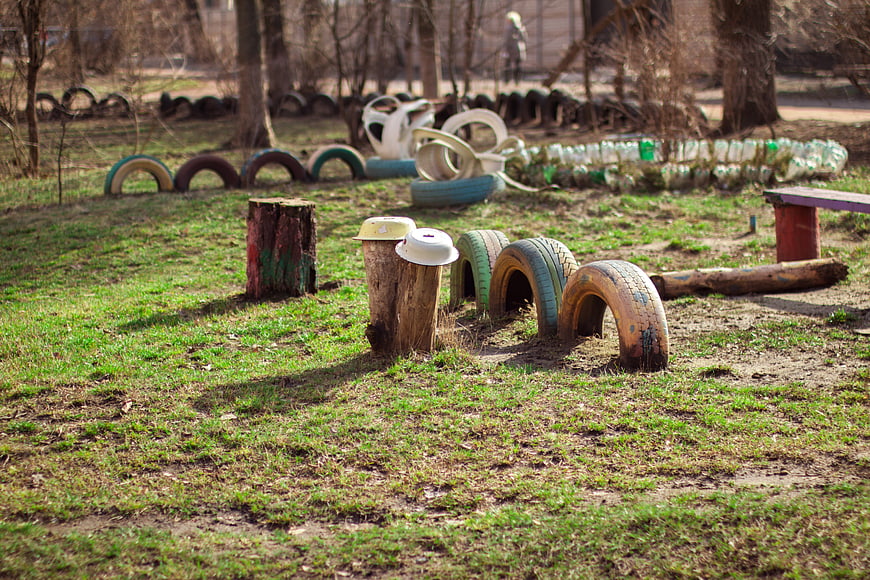 Outdoor playground with painted tires and wooden stumps