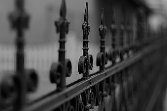 Close-up of ornate black wrought iron fence spikes