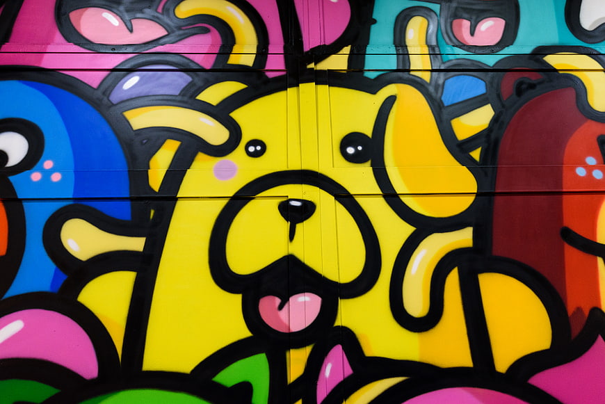 Colorful graffiti mural of a cute yellow dog character