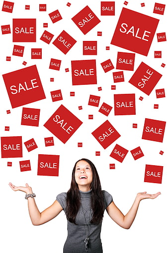 Happy woman looking up at floating red sale signs