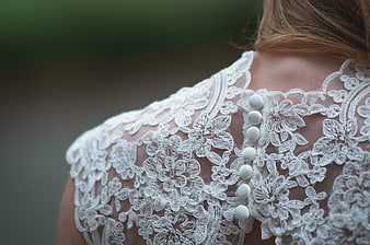 Close-up of white lace wedding dress back with pearl buttons
