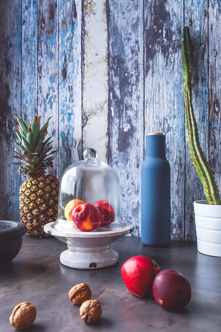 Still life of tropical fruits, nuts, and cactus on rustic blue wood