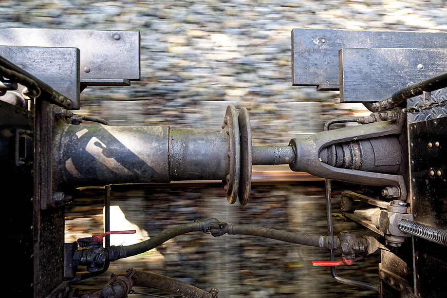Close-up of train coupling mechanism in motion on tracks
