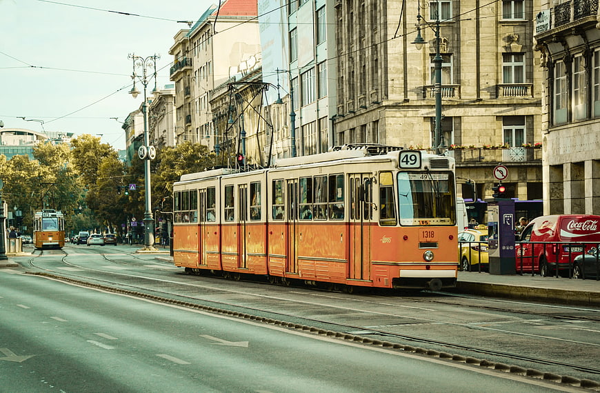 Vintage Orange Tram 49 on City Street with Architecture