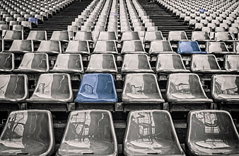 Blue Stadium Seat in Rows of Empty Gray Bleachers