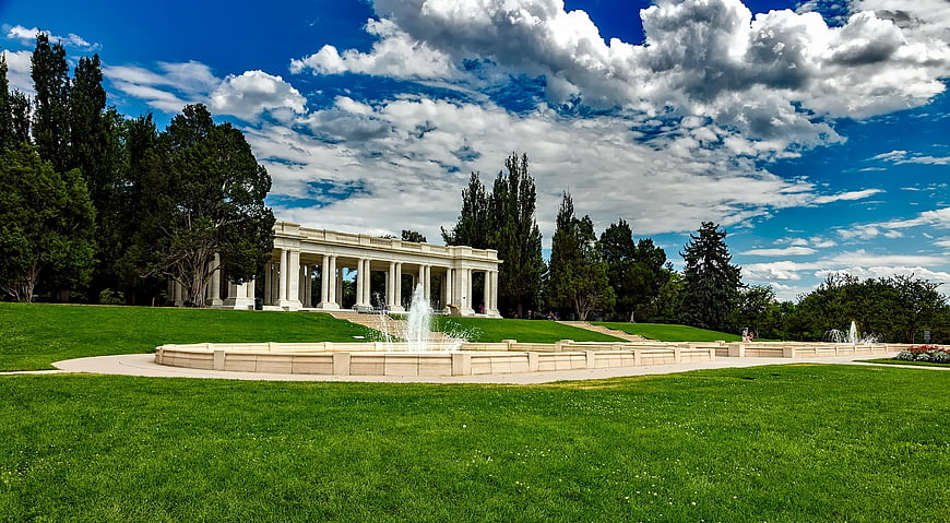 Classical colonnade building with fountain and green lawn