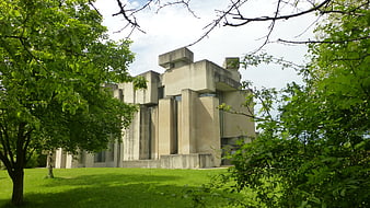 Modernist concrete church building framed by green trees