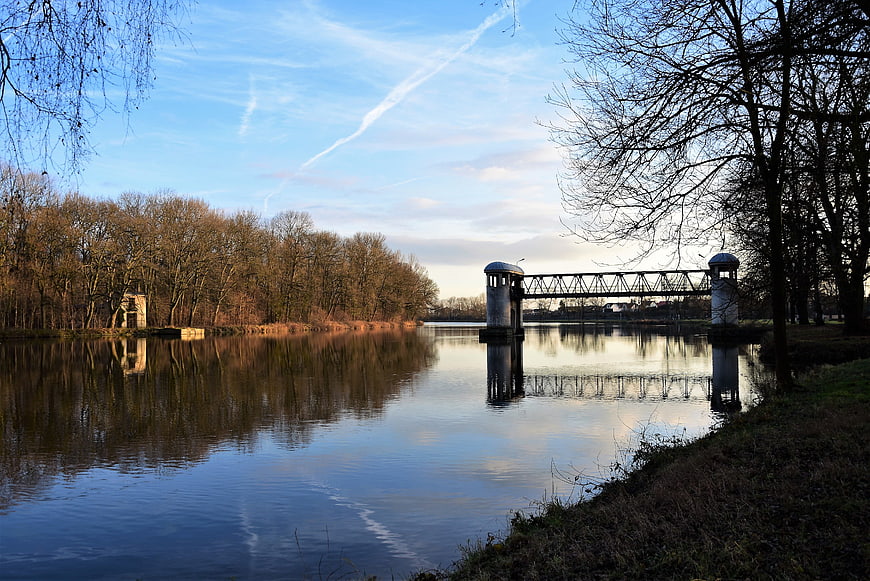 Serene River Landscape with Historic Lock and Bare Trees