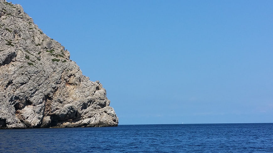 Rugged Rocky Cliff Against Blue Mediterranean Sea Sky