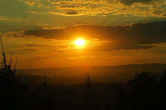 Golden Sunset Over Silhouetted Hills and Forest