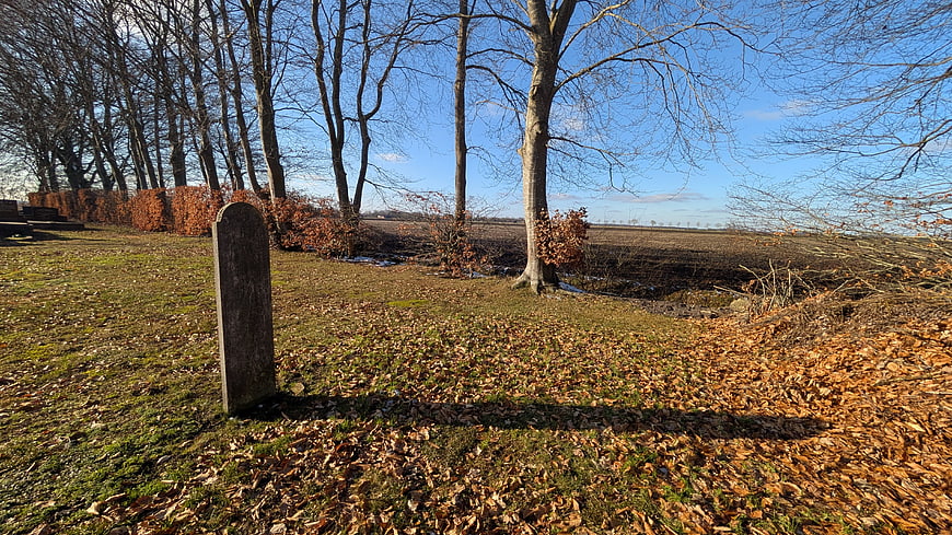 Old weathered gravestone in autumn cemetery landscape
