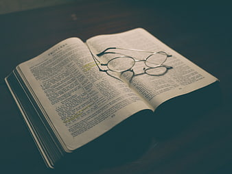 Open Bible with Glasses on Wooden Table