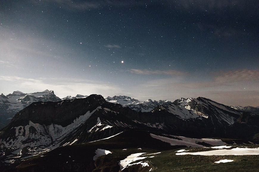 Snowy Mountain Range Under Starry Night Sky