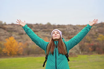 Happy woman hiking with arms raised in autumn nature