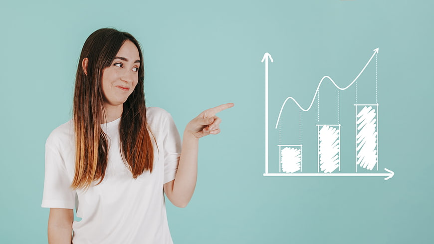 Young woman pointing at growth chart on blue background