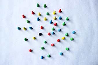 Colorful wooden game pieces on white paper background