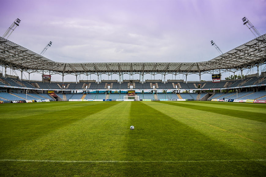 Empty Soccer Stadium with Ball on Green Grass Field