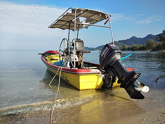 Yellow motorboat with Yamaha engine on tropical beach