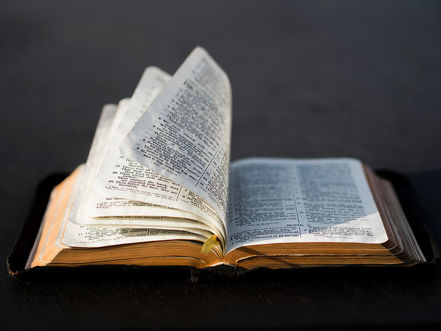 Open Bible with Pages Turning in Wind
