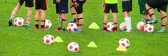 Children's Soccer Training Session With Footballs And Cones On Grass