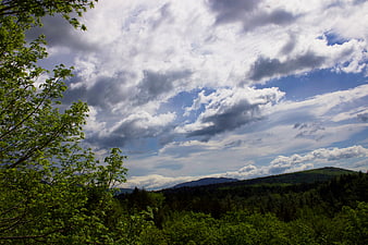 Dramatic Cloudy Sky Over Green Forested Mountain Landscape
