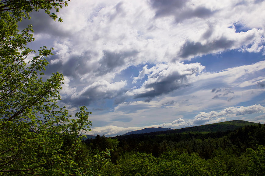 Dramatic Cloudy Sky Over Green Forested Mountain Landscape