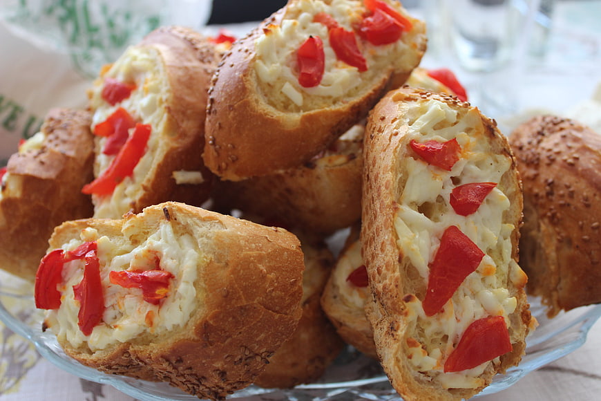 Cheesy bread rolls with red peppers on a glass plate