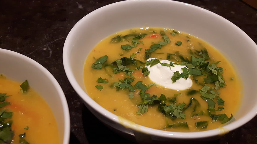 Bowl of Indian Lentil Pumpkin Soup with Spinach and Yogurt