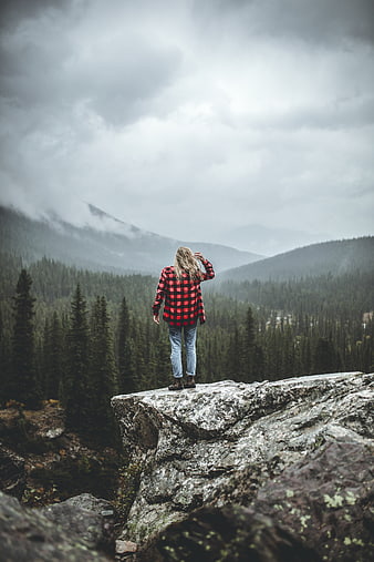 Woman in Red Flannel Standing on Rocky Mountain Cliff