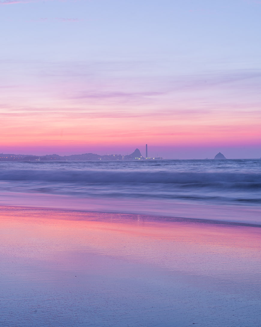 Serene Pink Sunset Beach with Smooth Ocean Waves