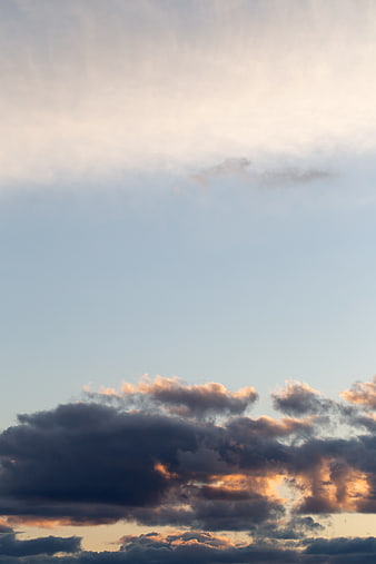 Dramatic sunset clouds with golden light against blue sky