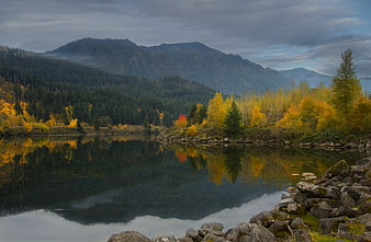 Serene Autumn Lake with Mountain Reflections and Golden Foliage