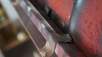 Close-up of masking tape on red painted metal edge