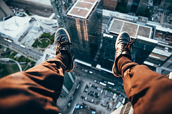 First-person view of legs dangling over a city skyline