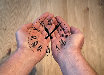 Hands holding clock face on wooden background