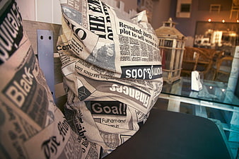Close-up of Newspaper Print Throw Pillows on Bench