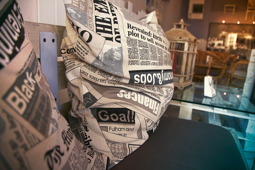 Close-up of Newspaper Print Throw Pillows on Bench
