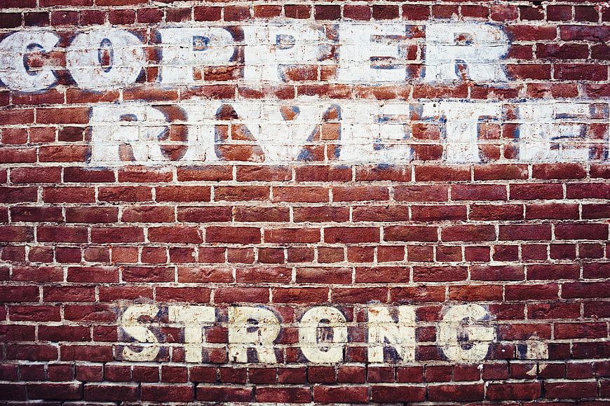 Vintage Ghost Sign on Red Brick Wall