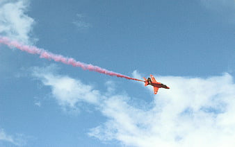 Red Jet Plane with Pink Smoke Trail in Blue Sky