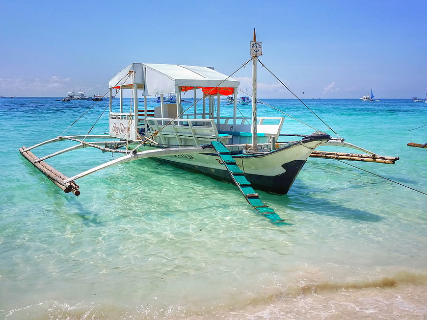 Traditional Filipino outrigger boat in turquoise tropical waters