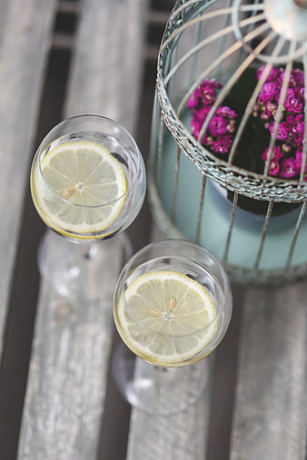 Top view of lemon water glasses and purple flowers