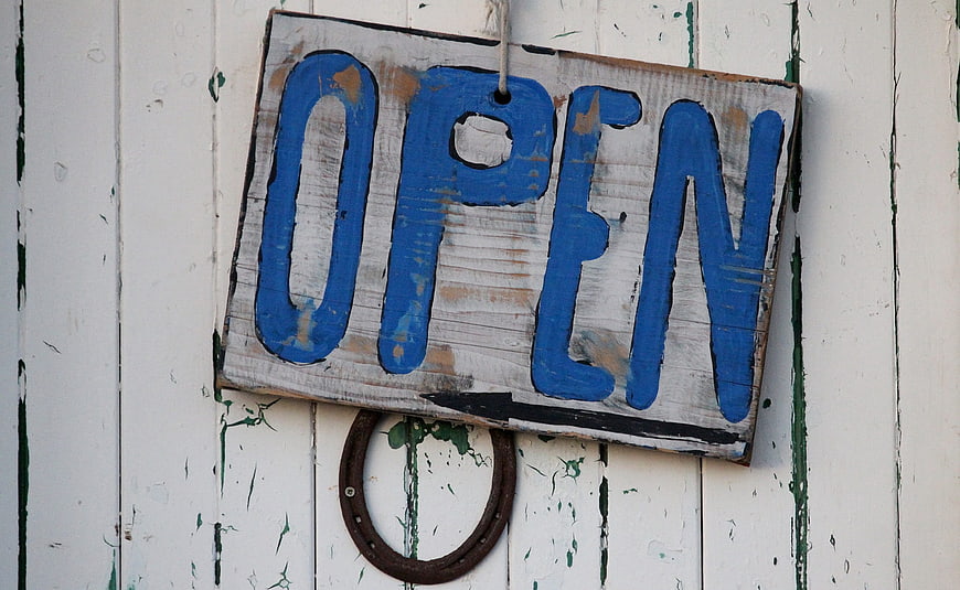 Rustic Wooden Open Sign on Weathered White Door