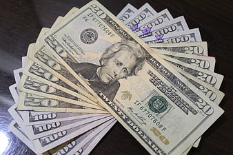 Fanned US Dollar Bills On Dark Wooden Table