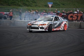 Drift car racing on track with smoke and crowd